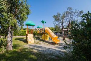 a playground with a slide in a park at Camping Le Palme in Marina di Bibbona