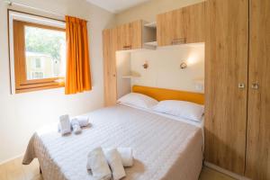 Camping Le Palme في مارينا دي بيبونا: غرفة نوم بها سرير عليه منشفتان +99 صورة