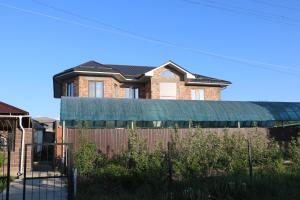 a brick house with a fence in front of it at Karakol Yurt Lodge & Homestay in Karakol