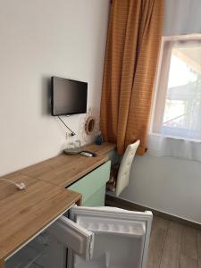 a room with a desk with a computer and a window at Camere de inchiriat Sibel in Costinesti +13 photos