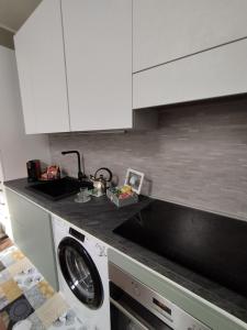 a kitchen with a sink and a washing machine at SKY LOFT Nuovissimo vicinanze Metro in Turin