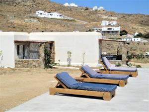 a row of lounge chairs sitting on top of a building at Megusta Mykonos in Tourlos