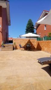 a patio with two chairs and a table and an umbrella at La casa de Clara Puente Arce in Arce