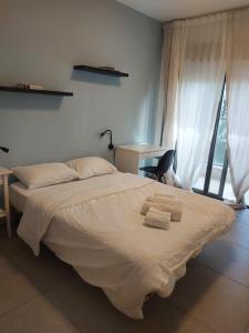 a bedroom with a large bed with towels on it at Family Apartment By IsrApart in Ramat Gan