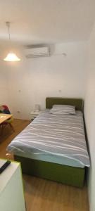 een slaapkamer met een groen bed in een kamer bij Apartmani Palmas Rijeka in Rijeka