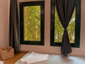 ein Zimmer mit zwei Fenstern und Handtüchern auf dem Boden in der Unterkunft Nisea Hotel Samos in Pythagoreio