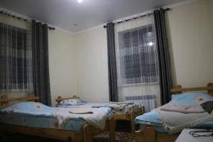 Postel nebo postele na pokoji v ubytování Tündük Guest House, Karakol