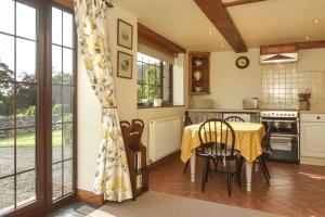 a kitchen and dining room with a table and chairs at Clays View Alstonefield in Alstonfield