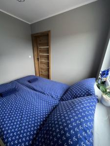 1 dormitorio con cama azul y edredón azul en Domki u Anety, en Górkło