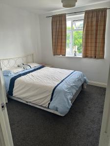 uma cama num quarto com uma janela em Lovely 2 bedroom Flat at Palm Court in Bournemouth,5 minutes away from beach, whole flat is yours for the time you stayed em Bournemouth