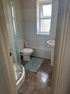 a bathroom with a toilet and a sink and a window at Lovely 2 bedroom Flat ,5 minutes away from beach, whole flat is yours for the time you stayed in Bournemouth