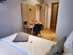 Zimmer mit einem Bett, einem Schreibtisch und einem Tisch in der Unterkunft Hotel Landhaus zur Issel in Isselburg