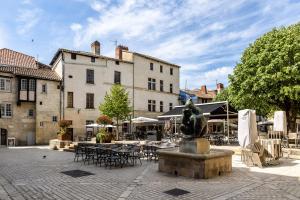 a courtyard with tables and chairs and a statue at Le Vintage in Périgueux