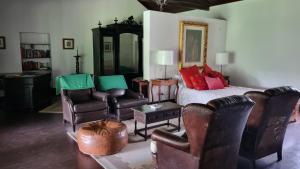 a living room with a bed and leather chairs at Quinta do Sanguinhal in Rio Maior