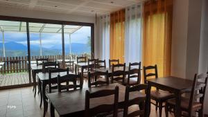 a restaurant with tables and chairs and a balcony at Refuge de Roncharel in Annot