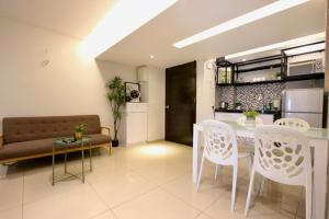 een keuken en een woonkamer met een tafel en stoelen bij Lovage Stay Melaka in Melaka