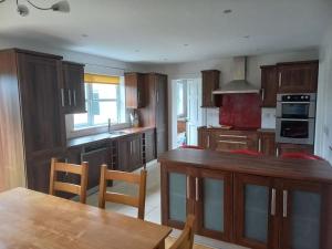 a kitchen with wooden cabinets and a wooden table and a table sidx sidx sidx at Buncrana Class 5 double bed in Buncrana