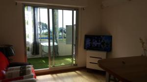 uma sala de estar com uma grande porta de vidro deslizante em BEAU STUDIO FRONT DE MER 2 mn DE LA PLAGE em La Ciotat