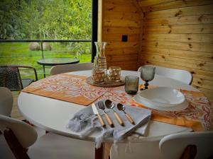 stół jadalny z talerzami i naczyniami w obiekcie WOOD HOUSE LAGODEKHI w mieście Lagodekhi