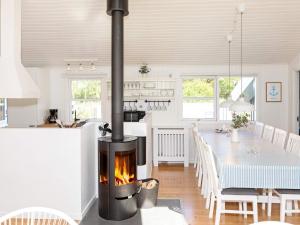 a kitchen and dining room with a fireplace in a room at Four-Bedroom Holiday home in Fjerritslev 3 in Torup Strand