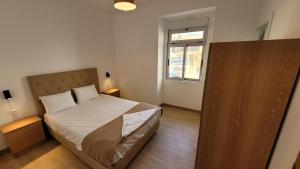 a small bedroom with a bed and a window at Stay in Sintra in Sintra