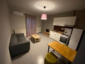 a kitchen and living room with a couch and a table at Voulas suites in Eleftheroúpolis