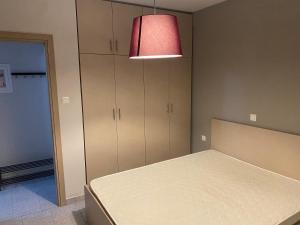 a bedroom with a bed and a red lamp at Voulas suites in Eleftheroúpolis