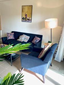 Appartement: Dakar-Plateau في داكار: غرفة معيشة مع أريكة زرقاء وطاولة
