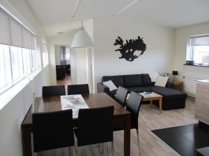 a living room filled with furniture and a table at Skýjaborg Apartments in Höfn