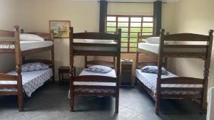 a room with four bunk beds and a window at Arca Pousada - 15 min do Thermas in São Pedro
