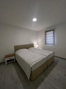 - une chambre avec un grand lit et une fenêtre dans l'établissement Apartmani Zeleni Vrtovi, à Visoko