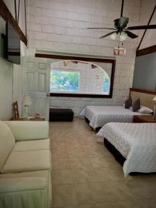sypialnia z 3 łóżkami, kanapą i oknem w obiekcie Casa de la O w mieście Yautepec
