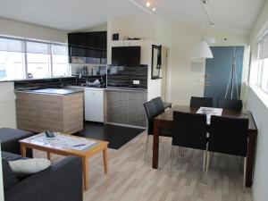 uma cozinha e sala de estar com mesa e cadeiras em Skýjaborg Apartments em Höfn