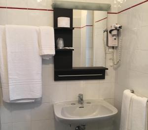 a bathroom with a sink and a mirror and towels at Hotel Valente in Ortona