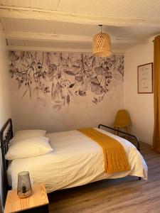 - une chambre avec un lit et un mur orné de fleurs dans l'établissement L’escapade de Tali, à Talizat