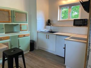a kitchen with blue and white cabinets and a stool at L’escapade de Tali in Talizat