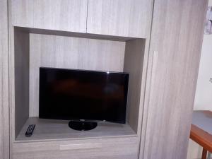 a flat screen tv in a wooden cabinet at Alice's House - Monolocale in Pula