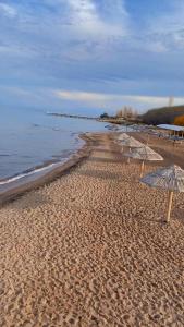 una playa con sombrillas en la arena y el agua en ЦО Париж сектор С18/5, en Chok-Tal