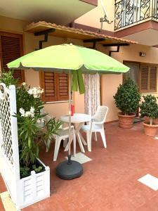 a green umbrella sitting on top of a patio at ELLE Monolocale - Sperlonga 50 mt dalla spiaggia con parcheggio in Sperlonga