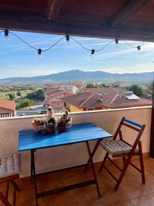 una mesa azul y una silla en un balcón con vistas en Charming apartment with parking, mountain view, close to the beach, en Santa María