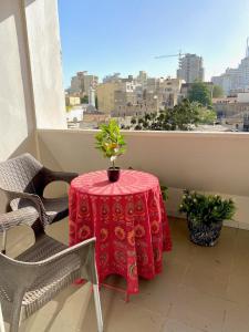 a table with a red table cloth on a balcony at Appartement: Dakar-Plateau in Dakar