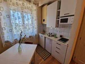 Flat II في Petroio: مطبخ صغير مع دواليب بيضاء وطاولة