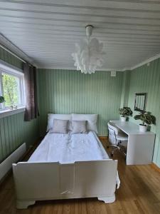 1 dormitorio con cama, escritorio y lámpara de araña en Cozy family house, en Tromsø