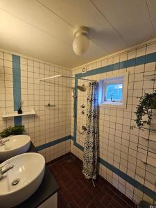 y baño con lavabo y ducha con cortina de ducha. en Cozy family house, en Tromsø