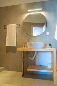 ein Bad mit einem Waschbecken und einem Spiegel in der Unterkunft @LAKE STUDIO in Ioannina