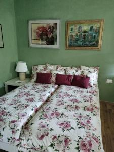 uma cama com um edredão floral num quarto em Casa relax immersa nel verde della natura em Casalborgone
