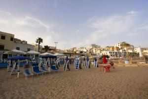 un grupo de sillas y sombrillas en una playa en Casa Vacanze Selinus, en Marinella di Selinunte