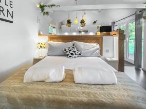 a bedroom with a large white bed with two pillows at The Little Barn in Hoxne