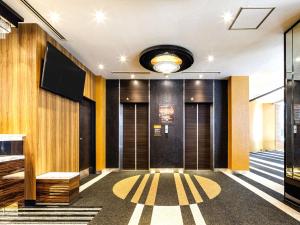 un couloir d'un immeuble aux murs jaunes et noirs dans l'établissement APA Hotel Nagasaki Dejima, à Nagasaki