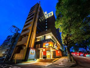a building on a street with a tree in front of it at APA Hotel Nagasaki Dejima in Nagasaki